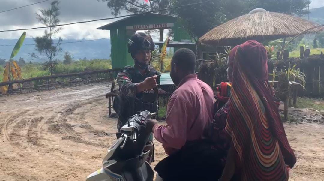 Tampak anggota TNI sedang membagikan Masker kepada warga. (Foto : Satgas Pamtas)