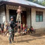 Tampak seorang anggota TNI sedang bersama anak anak Kabupaten Keerom Papua mengajarkan permainan Engrang. (Foto : Satgas Pamtas Yonif 126/KC)