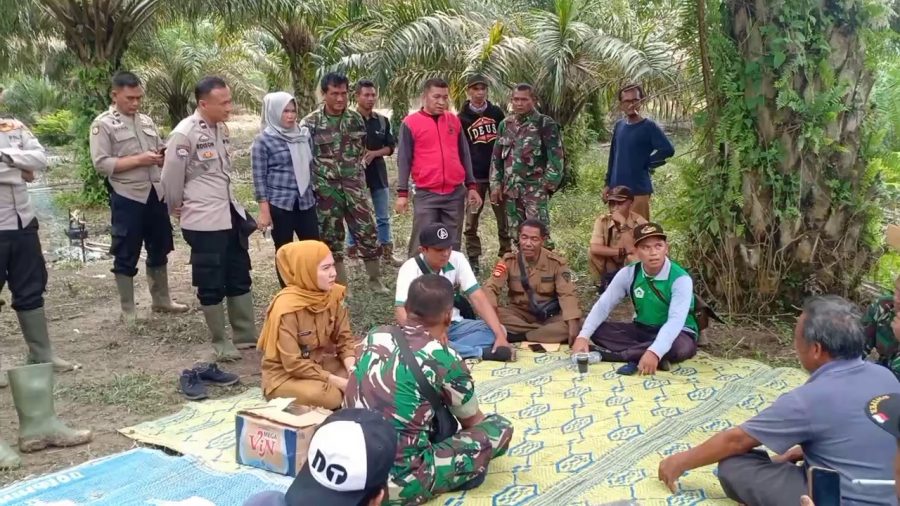 Kepala Desa Karang Raja, Okta Vianty sedang berdiskusi bersama warga, Babinsa, Bhabinkamtibmas terkait penggusuran lahan yang berada di wilayah Desa Karang Raja dan sekitarnya. (Foto : Gusti/enimtv)