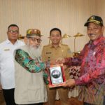 Disaksikan Pj Bupati Muara Enim, Kurniawan AP,.M.Si. Ketua FKUB Kabupaten Muara Enim serahkan Cinderamata ke FKUB Kabupaten Ogan Ilir di Balai Agung Serasan Sekundang Muara Enim