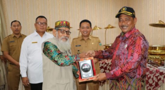 Disaksikan Pj Bupati Muara Enim, Kurniawan AP,.M.Si. Ketua FKUB Kabupaten Muara Enim serahkan Cinderamata ke FKUB Kabupaten Ogan Ilir di Balai Agung Serasan Sekundang Muara Enim